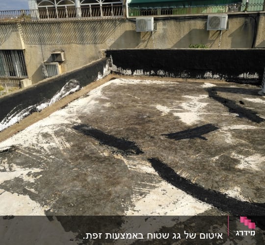 גג עם שכבת איטום ביטומנית שחורה ולבנה